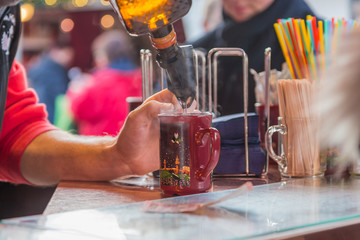 Berlin December 2016 - a bartender with a mulled wine glass offering mulled wine in the Christmas...