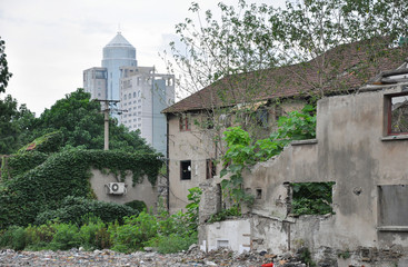 Old house on abridgment field in Shanghai with skyscraper behind