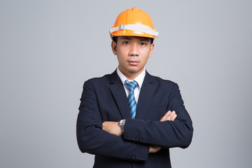 Portrait of a businessman in orange helmet on gray background