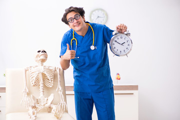 Funny doctor with skeleton in hospital