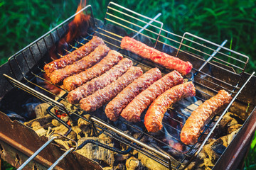 Grilling sausages on BBQ. Juicy beef. camping