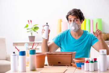 Young man decorating pottery in class