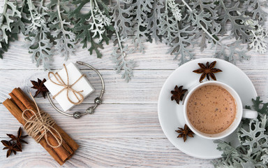 A gift for your beloved for any holiday - a fashionable jewellery bracelet with charms in a beautiful white box. Cineraria leaves, vanilla and cinnamon, a cup of coffee. Hygge Danish happiness. Autumn