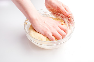 Making dough by female hands on white table