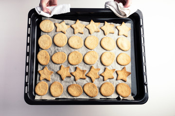 the process of making christmas cookies, raw dough, rolling pin and baking star forms.