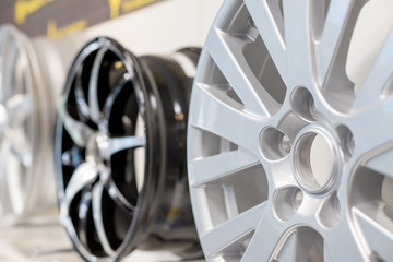 Car max wheel. Magnesium alloy wheel.Various alloy wheels in store, selective focus.car rims isolated.car rims isolated on shelf in a shop. Motor Show promotion or car workshop booklet or flyer design - obrazy, fototapety, plakaty