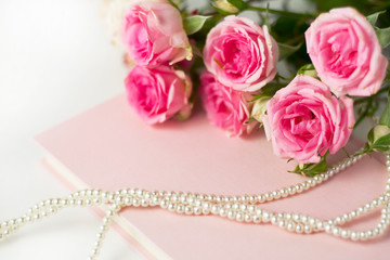  Pink flowers on a pink book with pearls.