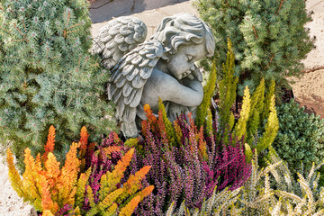 Ruhender Engel mit herbstlichem Grabschmuck