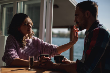 Girlfriend feeding her boyfriend with a cookie by the river