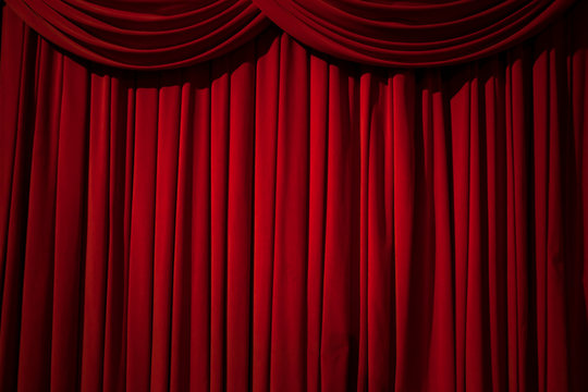 Large red curtain stage, with spot lights and dark background