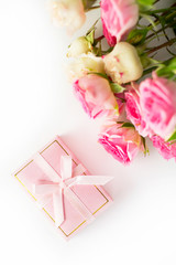  Pink gift box and roses on a white background. View from above.