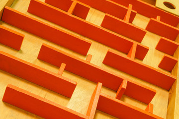 background - a top view of a maze of wooden partitions on a plywood floor