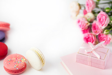  Multi-colored macaroons, flowers, gift box on a white background, suitable for a background.