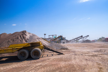 Crushing machinery, cone type rock crusher, conveying crushed granite gravel stone in a quarry open pit mining. Processing plant for crushed stone and gravel. Mining and Quarry mining equipment.