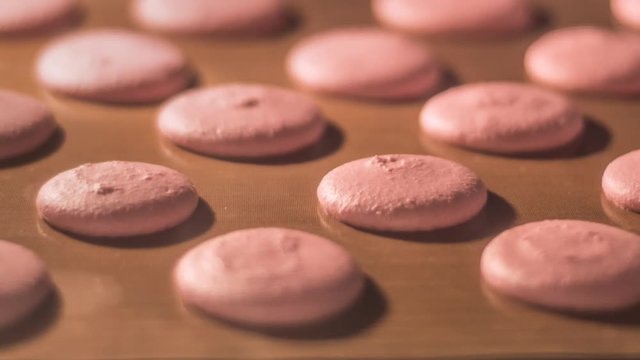 process of macarons baking in oven mitt. Close up 4K footage