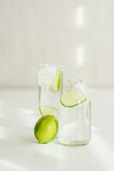 bottle and glass with water, ice and lime 