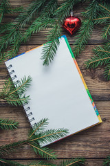 Tinted Christmas picture with a notebook and fir branches