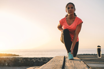 Health young woman stretching next the ocean during a magnificent sunset - Sporty girl work out on...