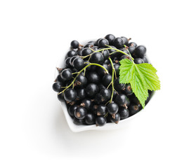 Fresh black currant in ceramic bowl isolated on white