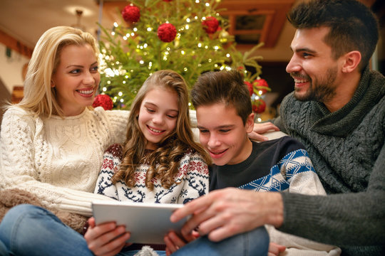 Family having fun while looking Christmas photos together