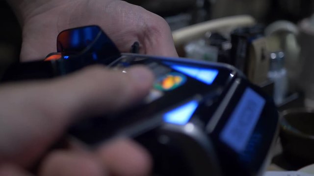 Wireless payment. Credit card payment terminal. Transfer payment. Woman paying through smart phone using NFC technology. Close up.