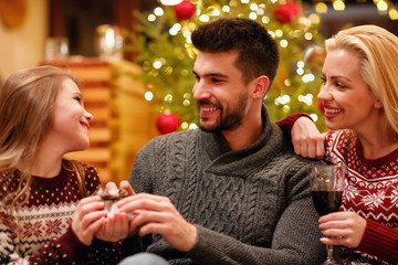 young family celebrating and exchanging gifts Christmas at home.