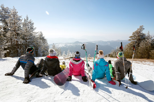Skiers resting on snow from skiing, back view