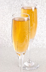Glasses of Champagne on a Silver Glitter Backdrop