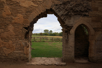 Arched doorways in ruin of old English church in the countryside