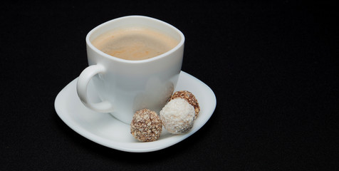 Coffee cup, beans, chocolate and macaroons on old kitchen table. Top view with copyspace for your text