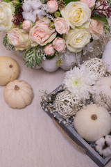 Fototapeta na wymiar bouquet of white pumpkins with chrysanthemum and gypsophila in a wooden box on a light background