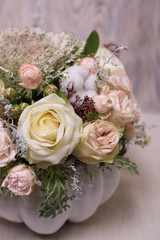 floral bouquet in a white pumpkin on a light background, a mixture of flowers, peony rose, eucalyptus, chrysanthemum, Brassica, white orchid, cotton