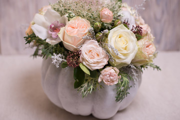 floral bouquet in a white pumpkin on a light background, a mixture of flowers, peony rose, eucalyptus, chrysanthemum, Brassica, white orchid, cotton
