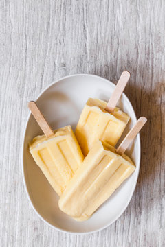 3 Orange popsicles on white