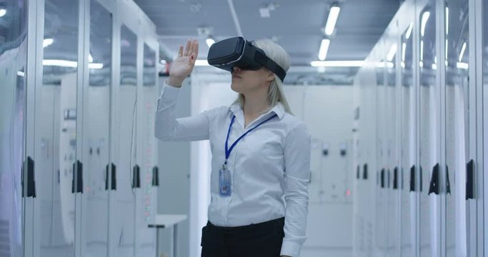 Formal blond woman wearing VR headset and working in control center of contemporary solar electrical plant