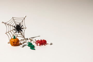 Composition of plastic toys for Halloween, with pumpkin, spider, cobweb, snake and bones