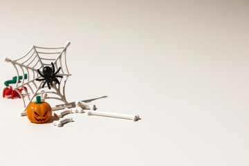 Composition of plastic toys for Halloween, with pumpkin, spider, cobweb, snake and bones