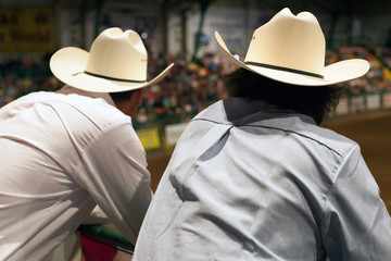 Two men watch a Texas rodeo