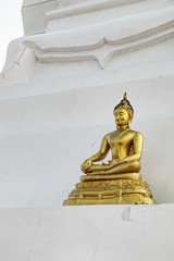 Old yellow-gold Buddha statue in Buddhist temple of Wat Phu Khao Thong, Ayutthaya historical park, Thailand. The statue is blackened by time.