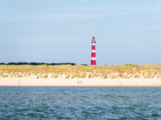 Beach and lighthouse of Ameland island in Waddensea, Friesland, Netherlands