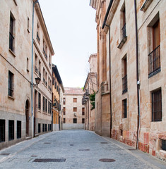 Paved street of old houses and lamps in the Spanish city of Toledo