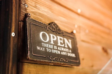 A business sign that says ‘Open’ on cafe or restaurant hang on door at entrance. Vintage color tone style.