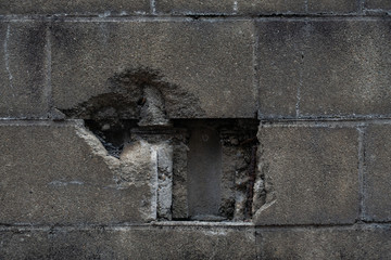 穴の開いたコンクリートブロック塀