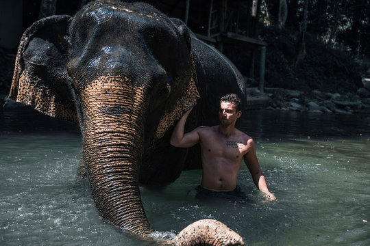 male with big elephant in the water