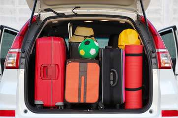 Closeup of rear side of white car carry luggage, suitcases and things for lovely family holiday. 