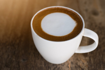 .hot coffee with foam milk on wooden background.