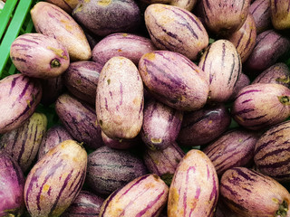 Fresh eggplant [ pepino  / tamarillo ] on basket at market 