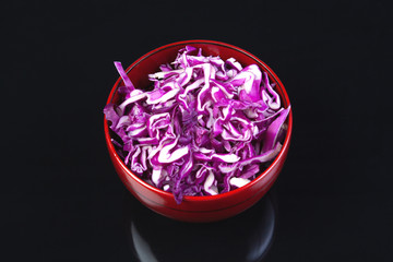 Shredded red cabbage in wooden bowl