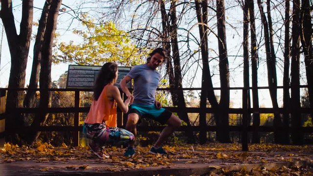 Medium shot. Couple dancing on the wooden bridge. Golden autumn