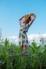 Schöne junge vitale sexy Frau im Sommerkleid, die in der Natur in der frischen Luft genießt...